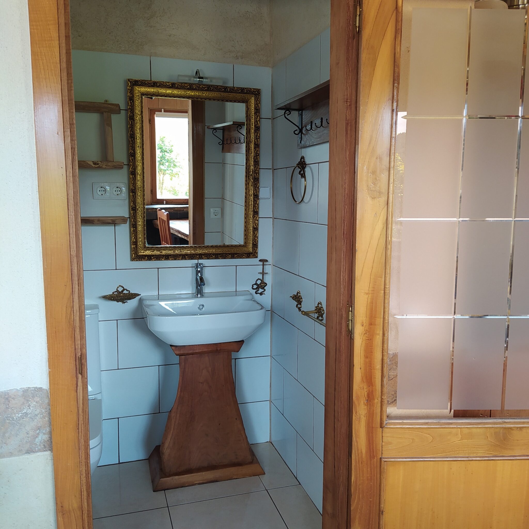 Baño privado en casa rural Loventuro con combinación de piedra, madera y funcionalidad.